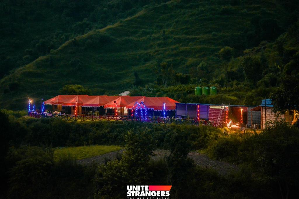 奈尼塔尔The Janvi Camping Resort的一辆装有圣诞灯的火车在田野上