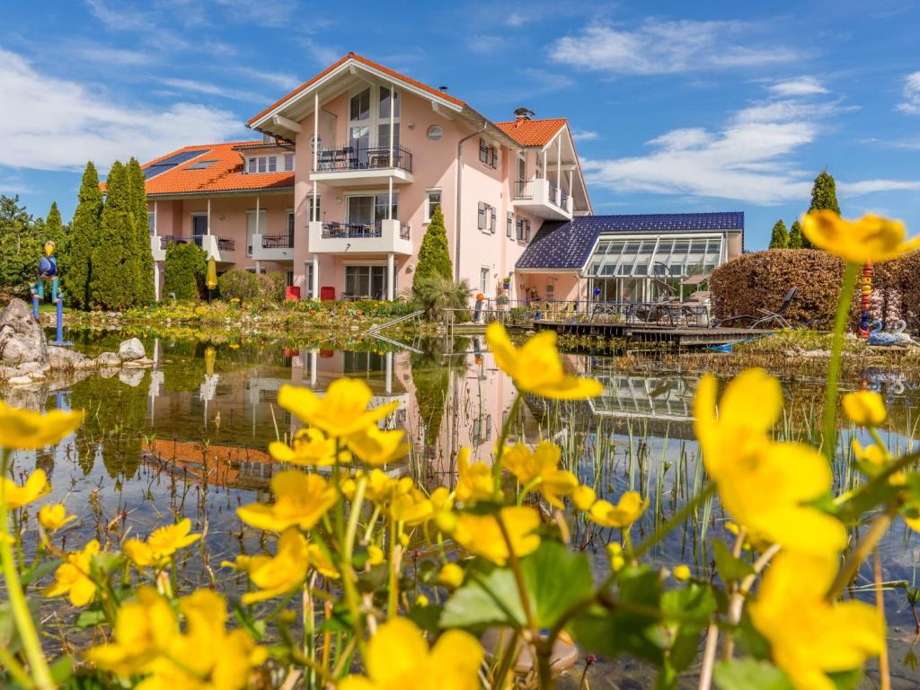 韦尔塔赫Wellnesshof Blenk的一座房子和一个种着黄色花的池塘