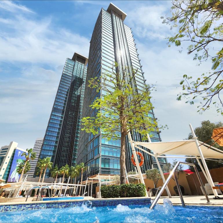 多哈多哈罗塔纳城市中心酒店的一座高楼前的游泳池
