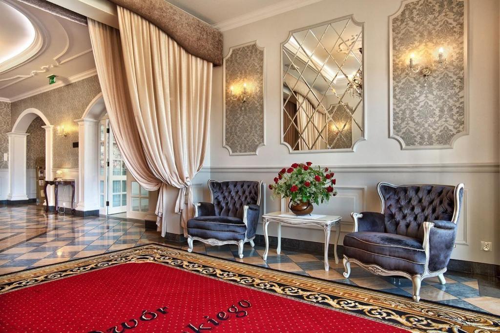 比亚韦斯托克瓦恰米切赫酒店的客厅配有两把椅子和红色地毯