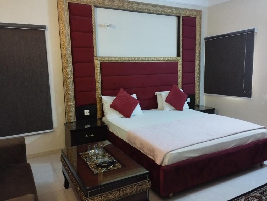 卡拉奇Hotel Shelton的一间卧室配有一张红色床头板的床