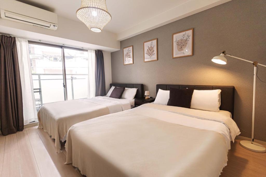 大阪b&道顿堀店的一间卧室设有两张床和窗户。