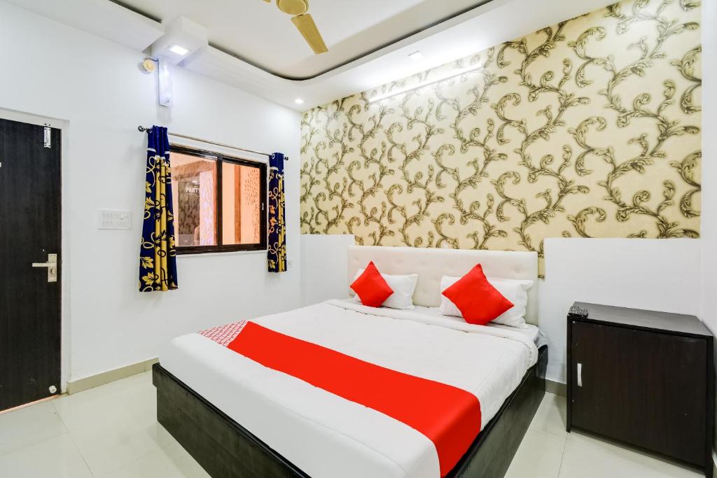 BārmerOYO Hotel Amber Palace的一间卧室配有红色枕头的床