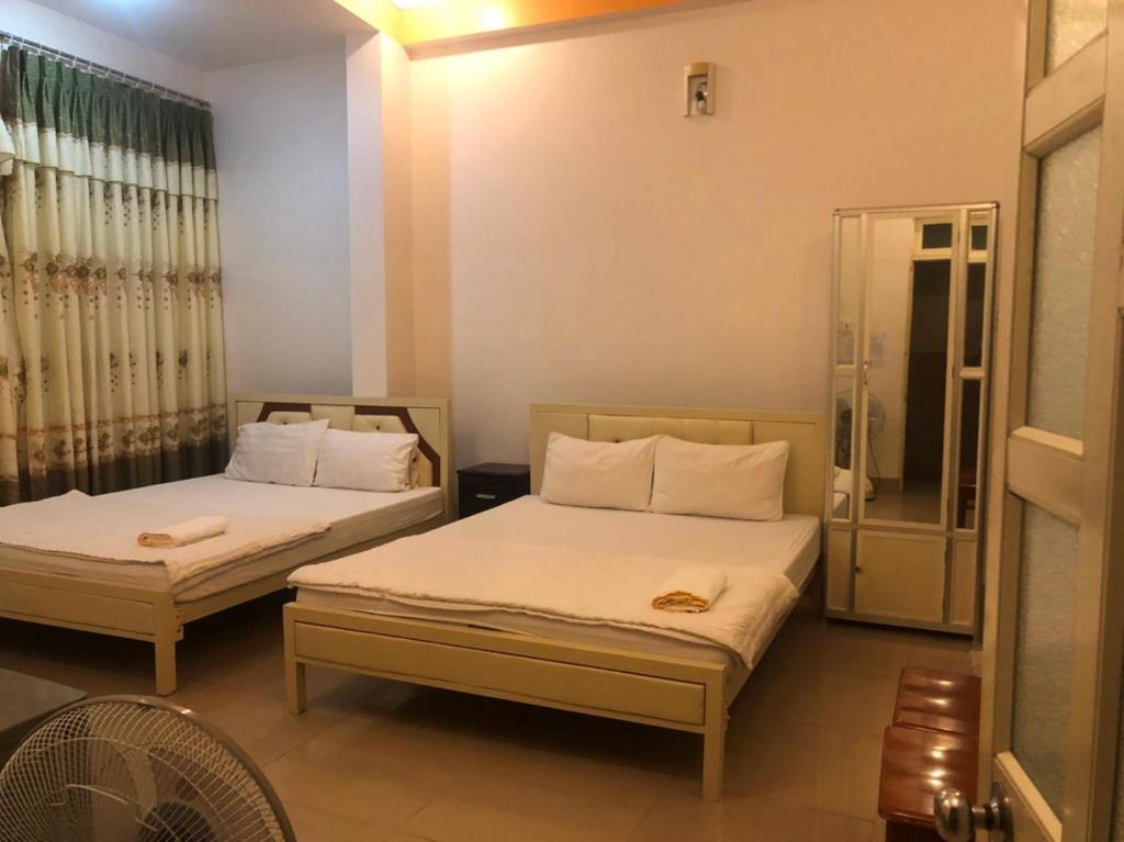 潘郎Nam Dương 3 Hotel的一间卧室设有两张床和淋浴。