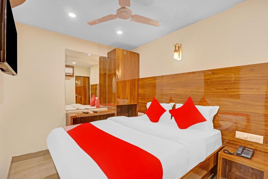 孟买OYO Hotel Royal Park的一间卧室配有一张带红色枕头的大床
