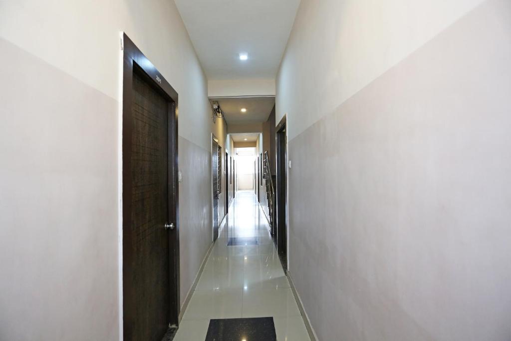 科塔OYO HOTEL SHRI KALYAN的走廊上设有白色的墙壁、门和走廊