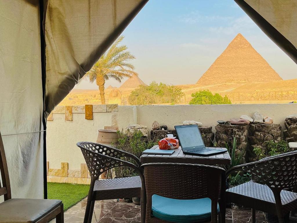 开罗Kemet Pyramids Room view的一张桌子,上面有一台手提电脑和金字塔