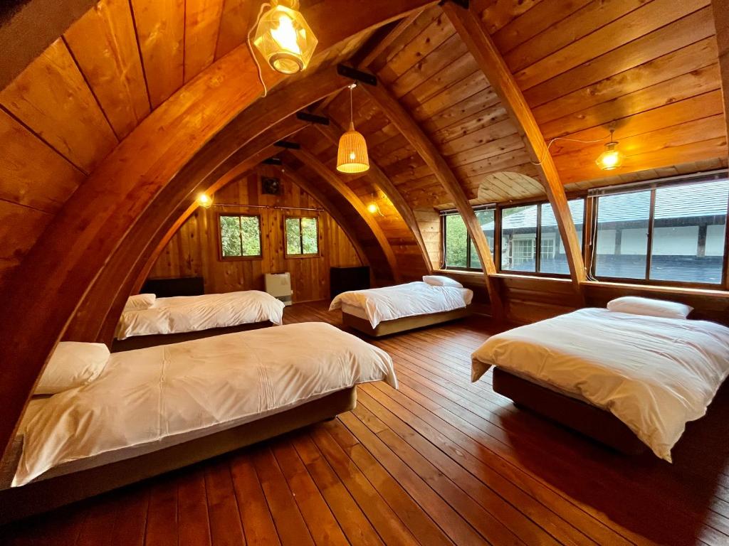 白马村Hakuba Mountain Cabin的一间阁楼卧室,房间内设有三张床