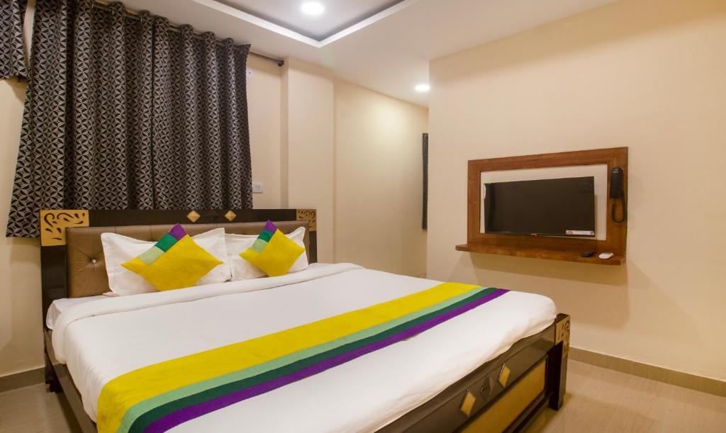 商沙巴Itsy By Treebo - Yogeshwara Grand的一间带大床和电视的卧室