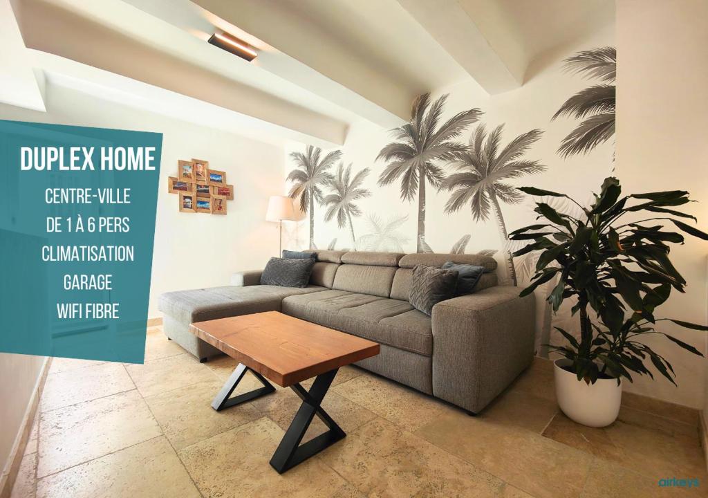 朗贝斯克*Duplex Home Lambesc*Clim Garage的客厅配有沙发,墙上种植了棕榈树。