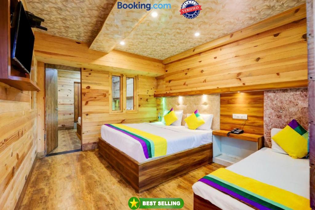奈尼塔尔Goroomgo Vinayak Mall Road Lake View Nainital - Luxury Room - Best Hotel in Nainital的小木屋内一间卧室,配有两张床