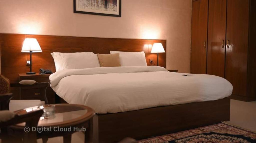 卡拉奇Ambassador Hotel Clifton的酒店客房带一张大床,带白色床单