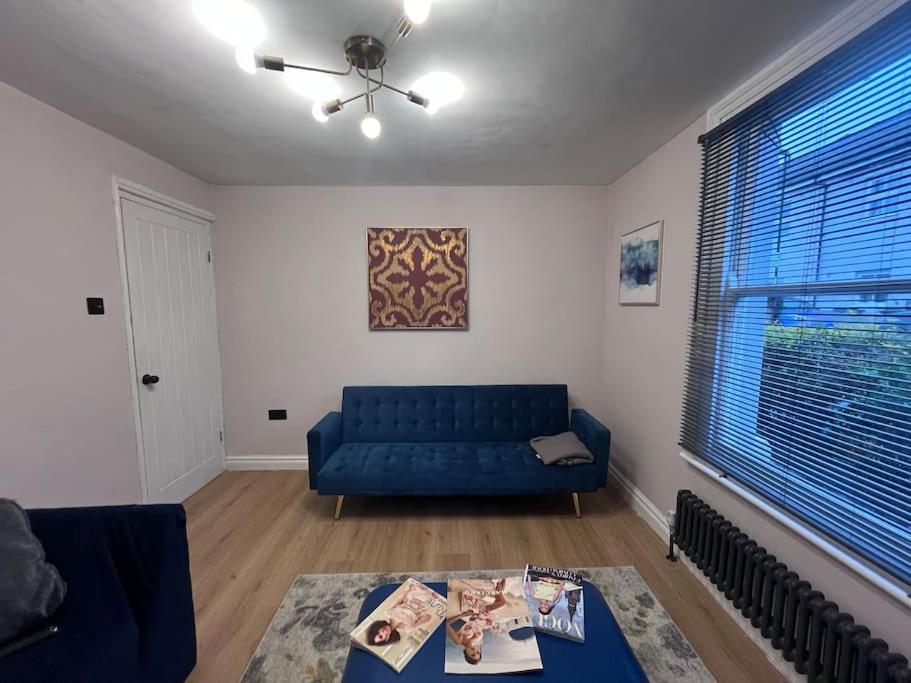 NorwoodStunning 3 bedroom house sleeps up to 6的客厅配有蓝色的沙发和桌子