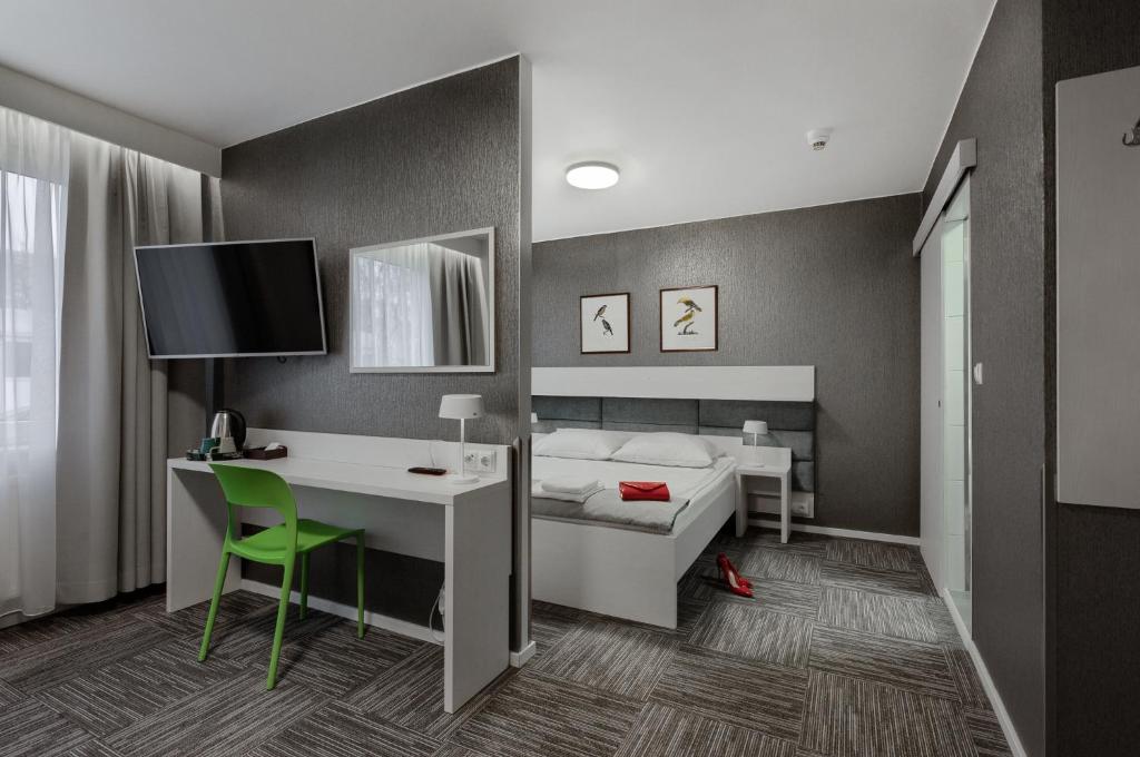 什切青Jantar Resort的一间卧室配有一张床、一张桌子和一台电脑