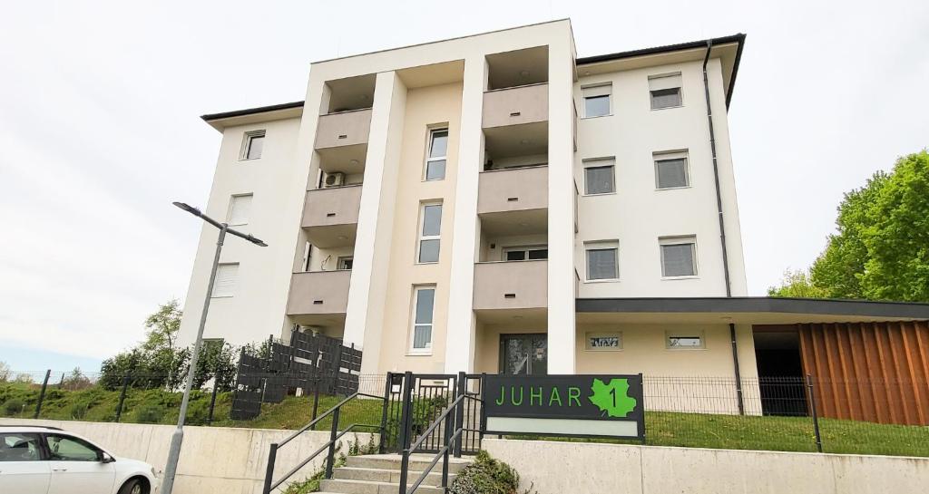 克塞洛Juhar 1 Apartman的前面有标志的白色建筑