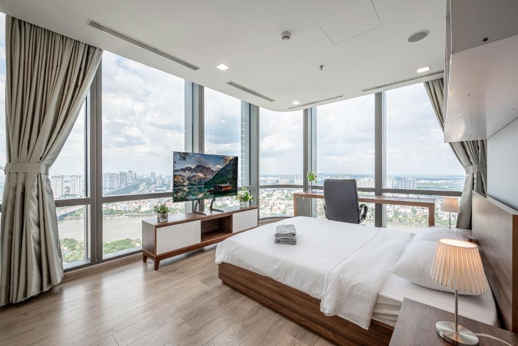 胡志明市THE LANDMARK 81 RESIDENCE LUXURY SUITE的一间卧室设有一张床、一台电视和窗户。