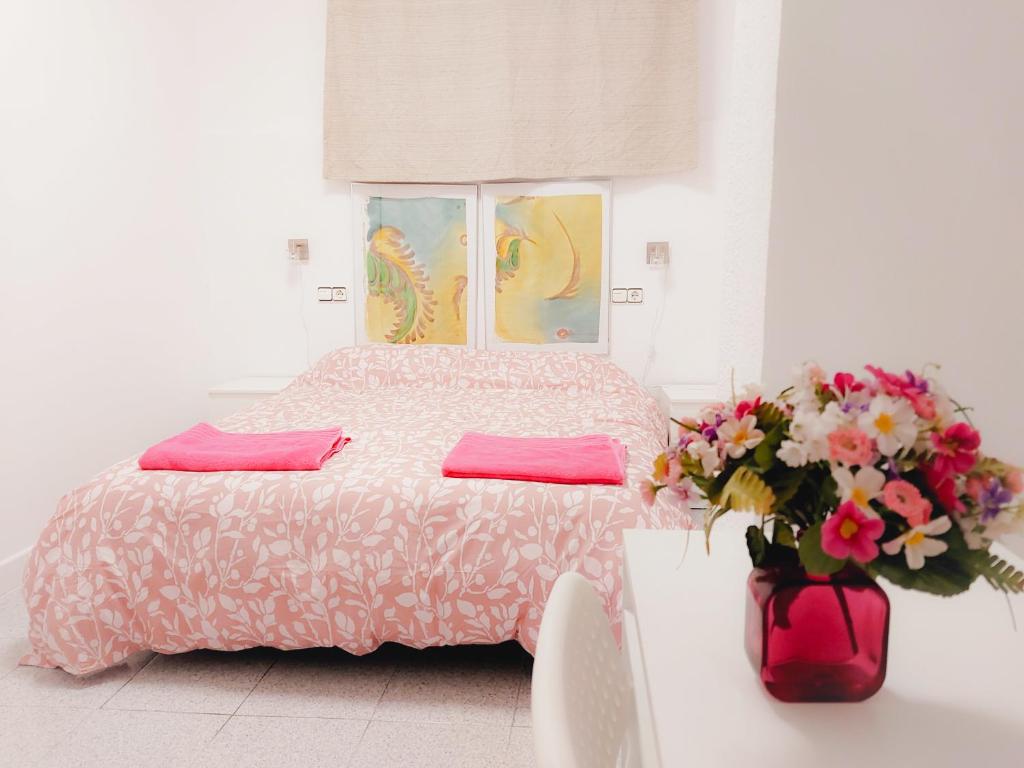 穆尔西亚Alojamiento San Juan en Murcia Centro的一间卧室,配有一张床和花瓶