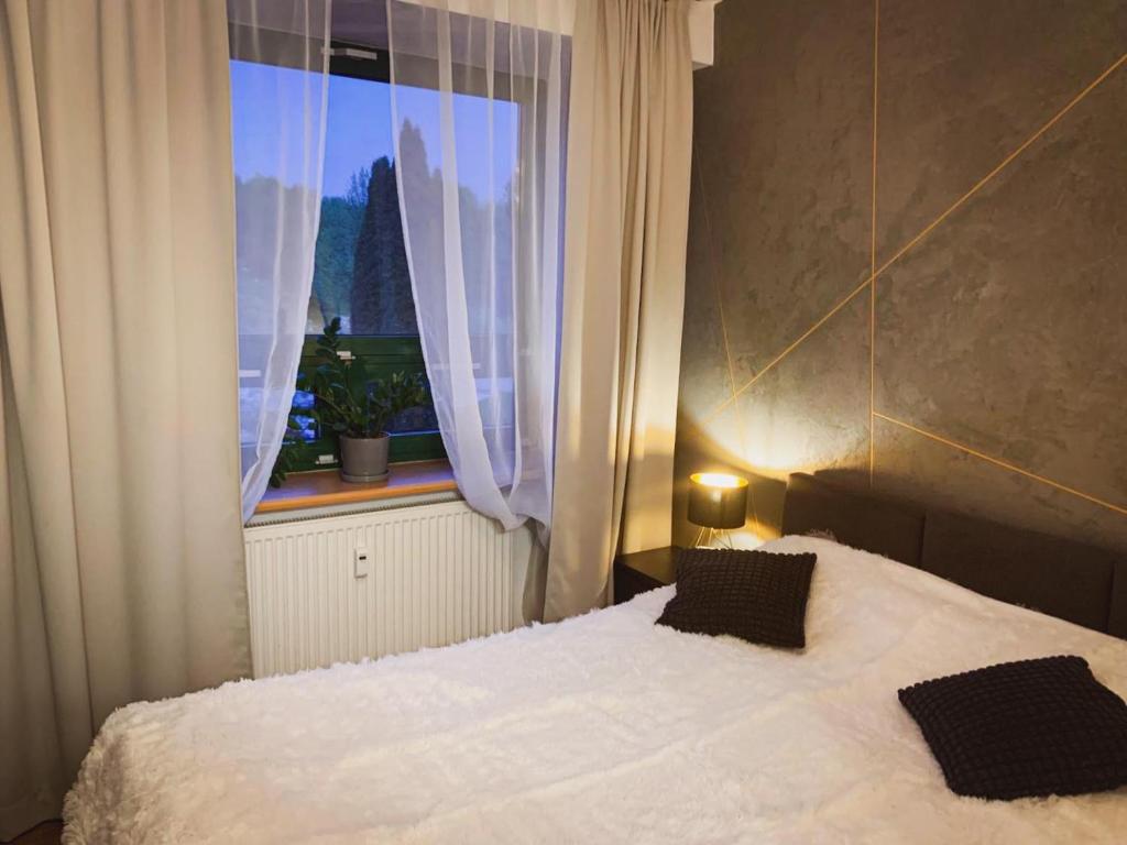 斯诺科Stylowy Apartament w Serocku的卧室配有白色的床和窗户。
