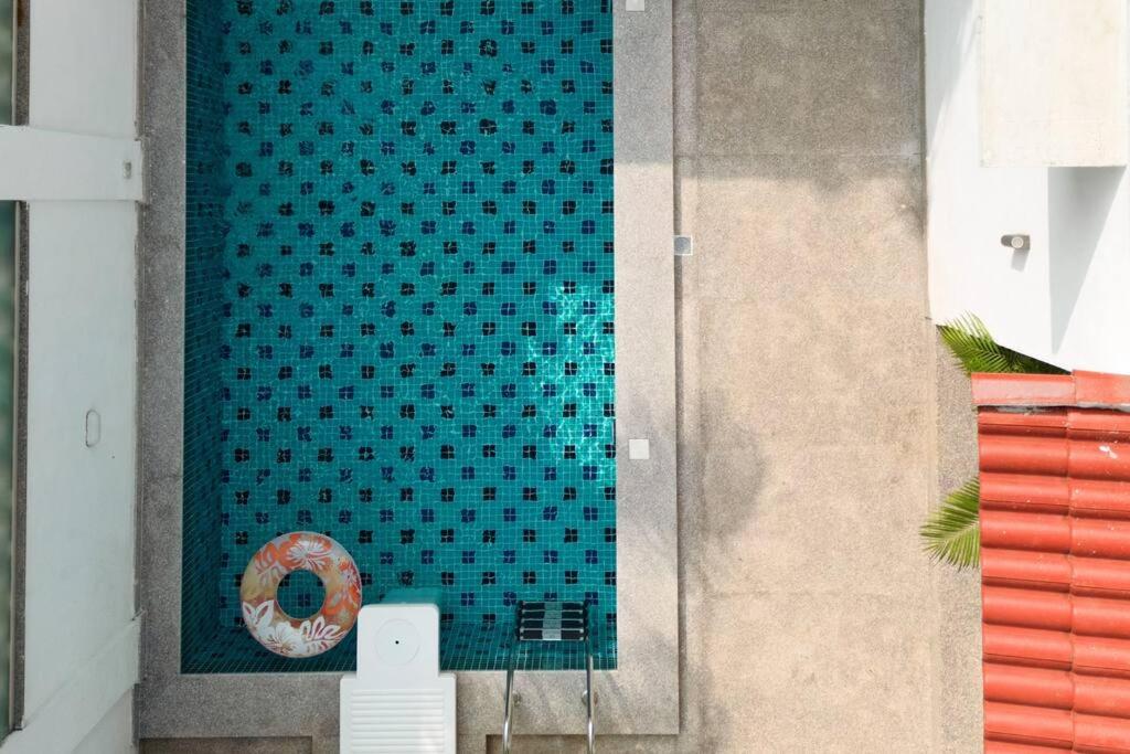 VerlaRa-3Bed Villa W/PVTpool in Assagao by Masaya Stays的蓝色瓷砖游泳池旁有甜圈