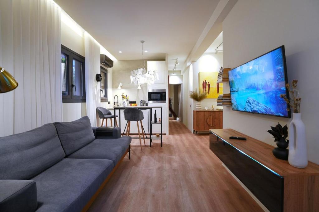 雅典P Faliro Riviera Suite的客厅配有沙发和墙上的电视
