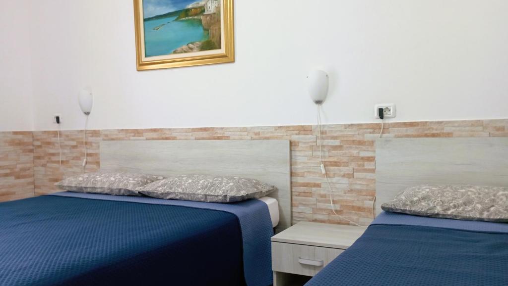 维耶斯泰Hotel Residence Villa Ascoli的配有两张床铺的蓝色床单和枕头