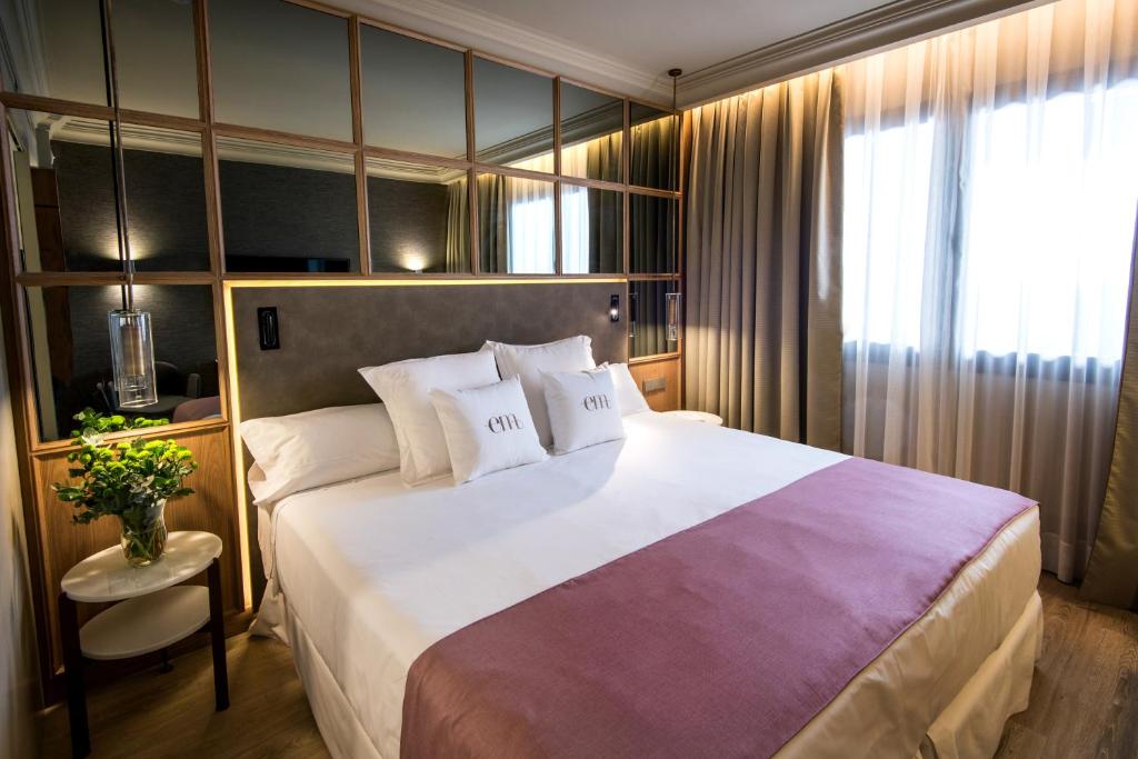 马德里巴塞罗帝国酒店的一间设有大床和窗户的酒店客房