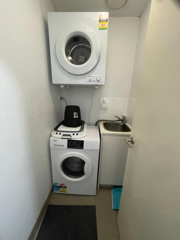 悉尼Ocean view 2 Bedroom apartment的小型浴室设有洗衣机和水槽。
