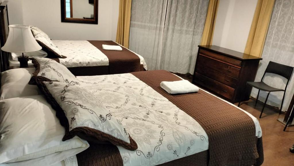 卡尔德拉Hotel 5° Estación的酒店客房带两张床和梳妆台