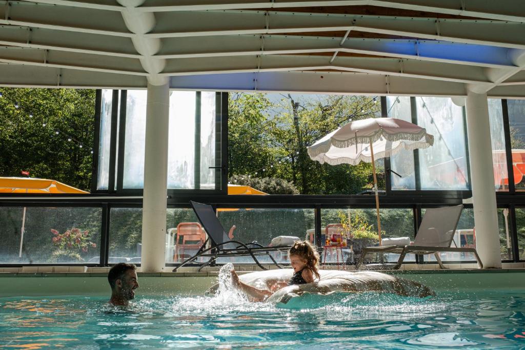 夏蒙尼-勃朗峰Big Sky Hotel的游泳池里的两个人