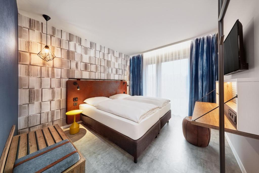 美因茨H2 Hotel Mainz的一间卧室配有一张床和一台电视。