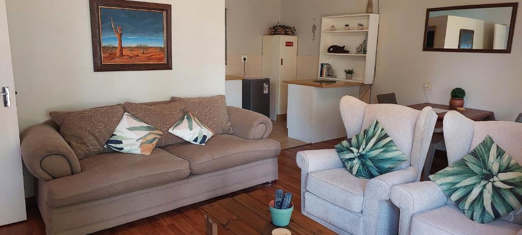 内尔斯普雷特Cicada's Call Guest Cottage的客厅配有沙发和两把椅子