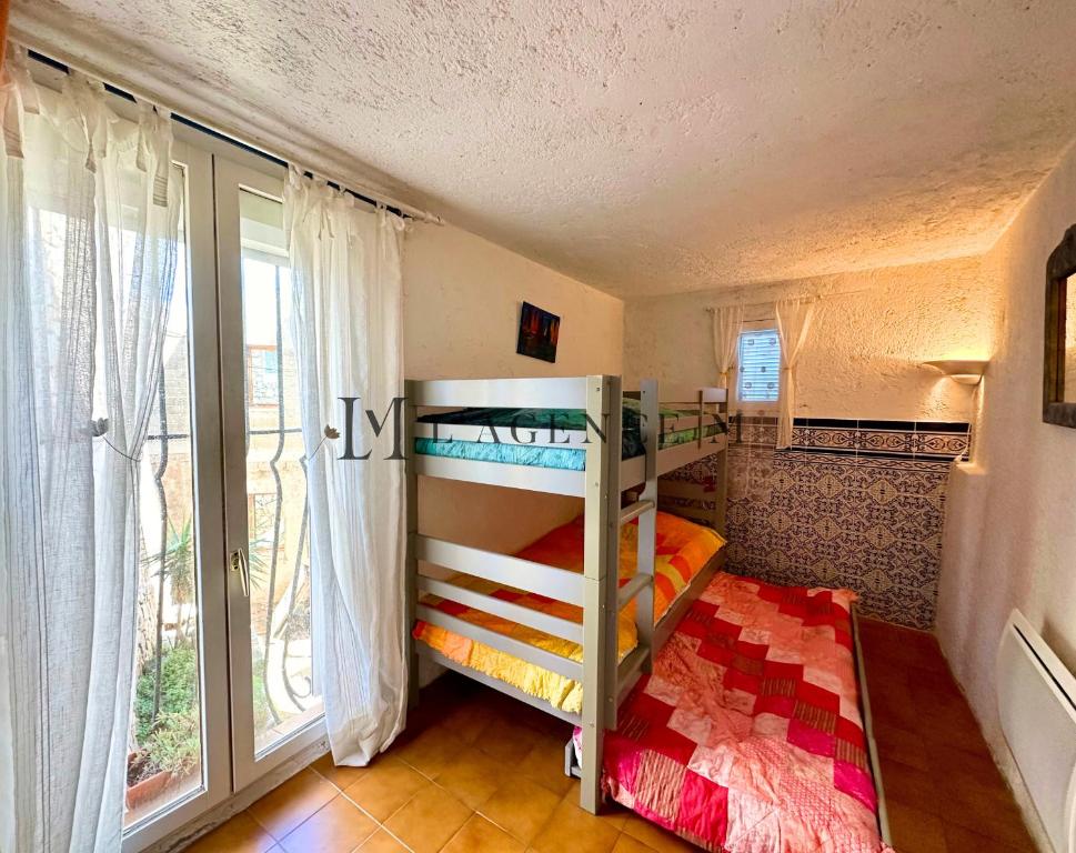 阿尔加约拉Maison de village typique bord de mer的一间卧室设有两张双层床和一扇窗户。