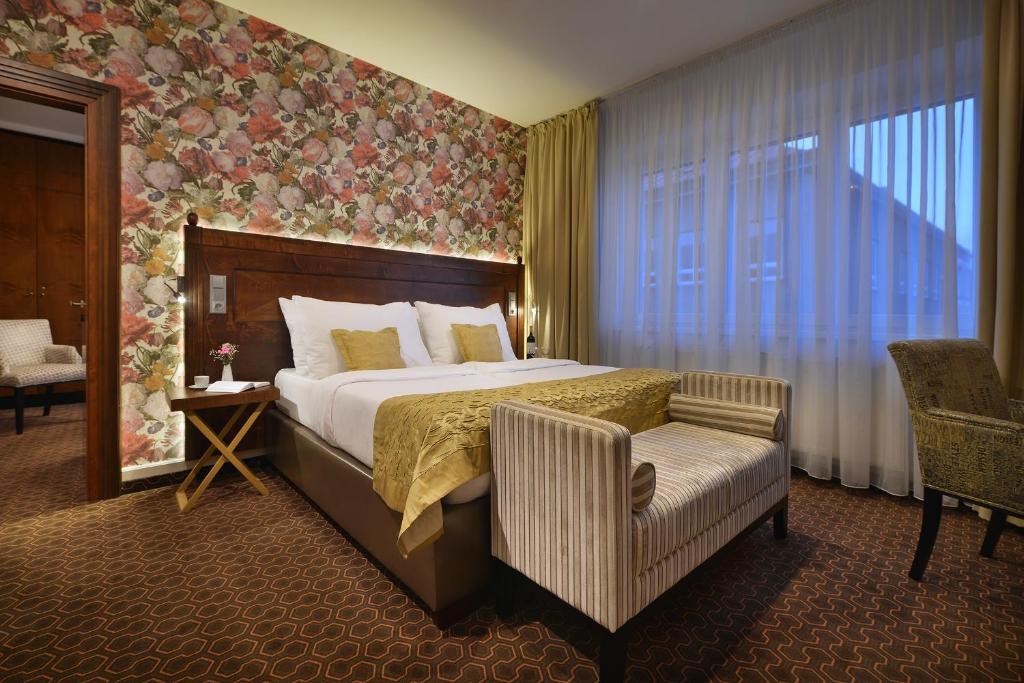 赫林斯科Vysocina Design Apartments的配有一张床和一把椅子的酒店客房