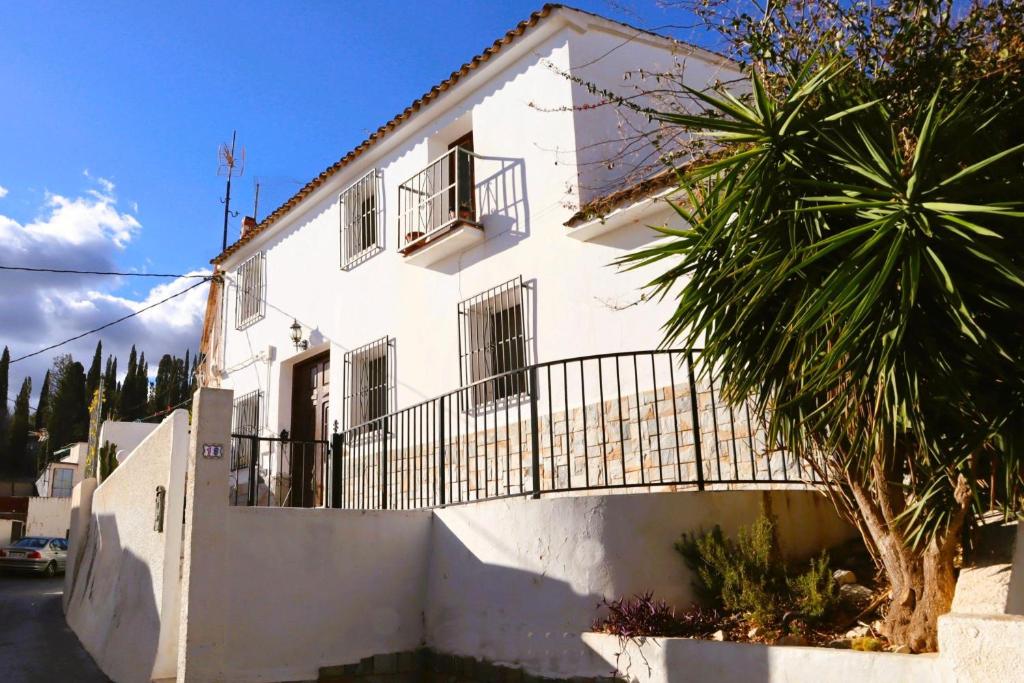 卡略萨登萨里亚Casa Paradís的带阳台的白色房屋和棕榈树