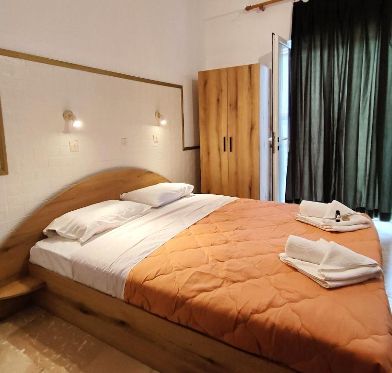 圣乔治斯Eleni Apartments Sant George Beach的一间卧室配有一张大床和两条毛巾