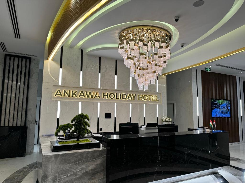 埃尔比勒Ankawa Holiday Hotel的大堂设有吊灯和酒店标志
