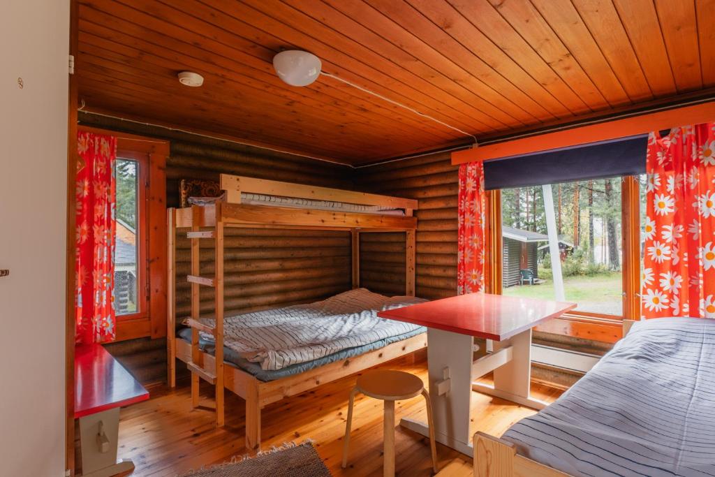 列克萨Lomakylä Timitraniemi的小屋内设有一间带双层床和桌子的卧室