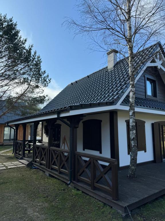 BartoszylasLeśna Osada na Kaszubach - drewniane domy na wynajem的白色的大房子,设有木门廊