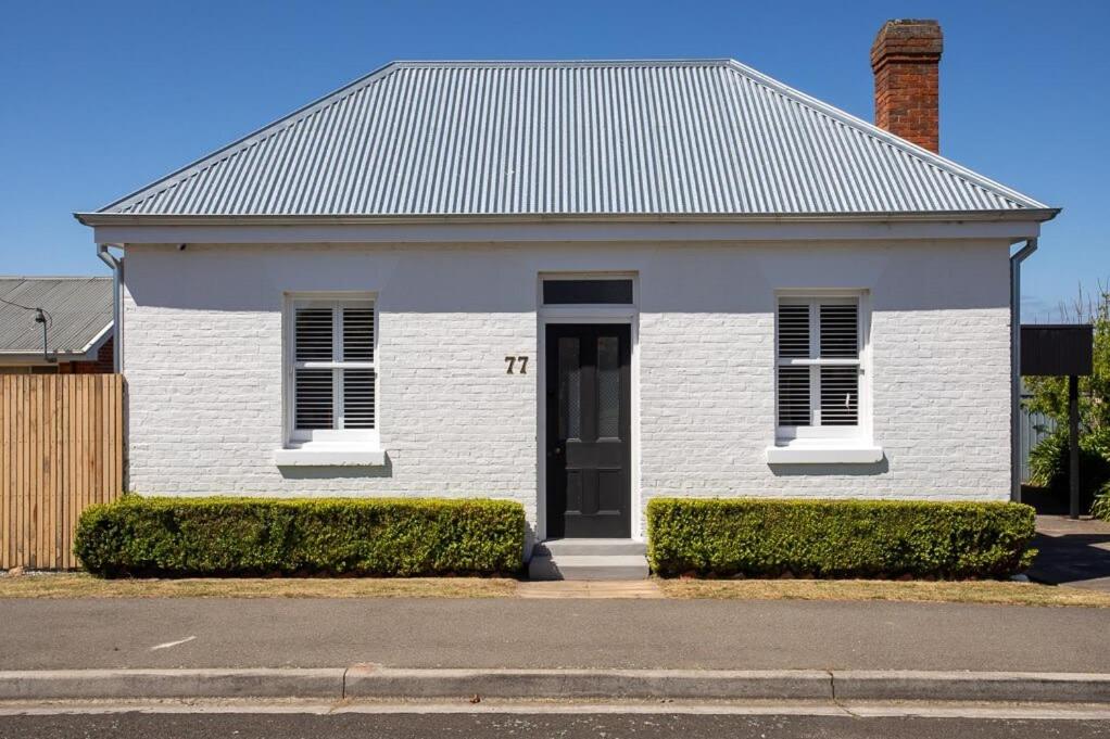 Perth'Clarence' - A historic cottage in Perth的街上有一扇黑门的白色房子