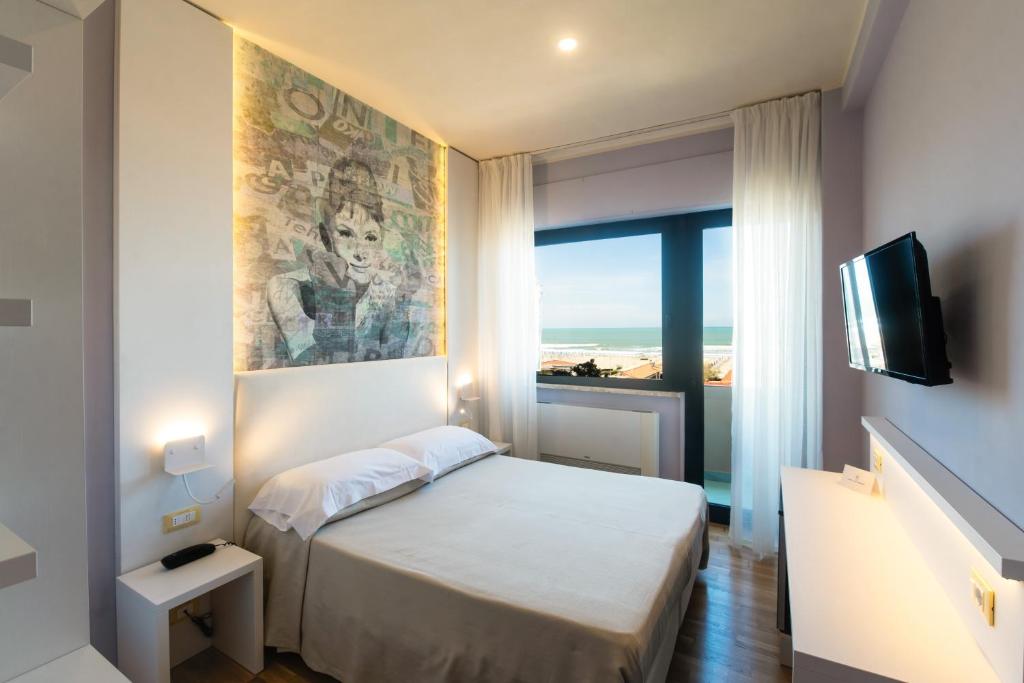 维亚雷焦圣弗朗西斯科酒店的一间带床和电视的小卧室