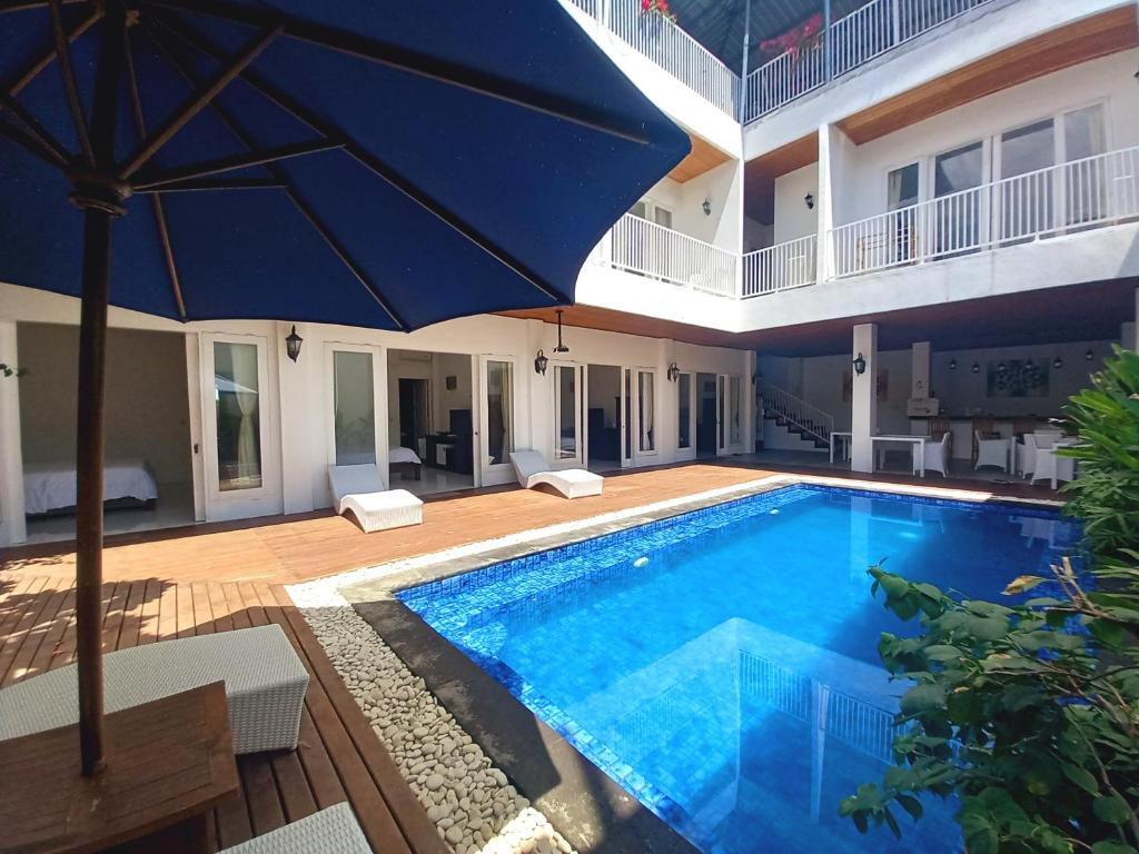 吉利特拉旺安Lumiere Hotel Gili Trawangan的一座房子旁边的带遮阳伞的大型游泳池