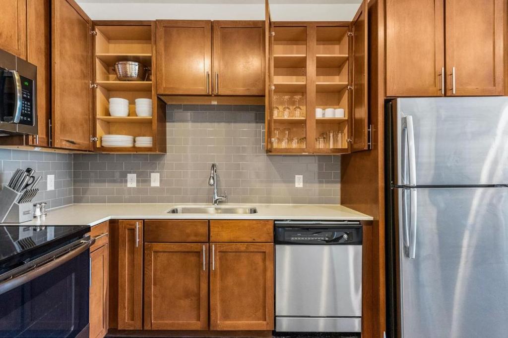 欧文Landing at City North - 1 Bedroom in Valley Ranch的厨房配有木制橱柜和不锈钢冰箱。