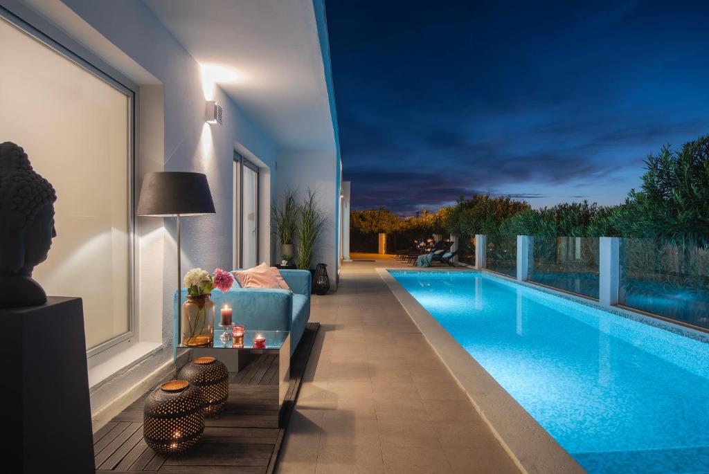 普拉Monvidal Residence - Adults Only的客厅设有蓝色沙发,毗邻游泳池