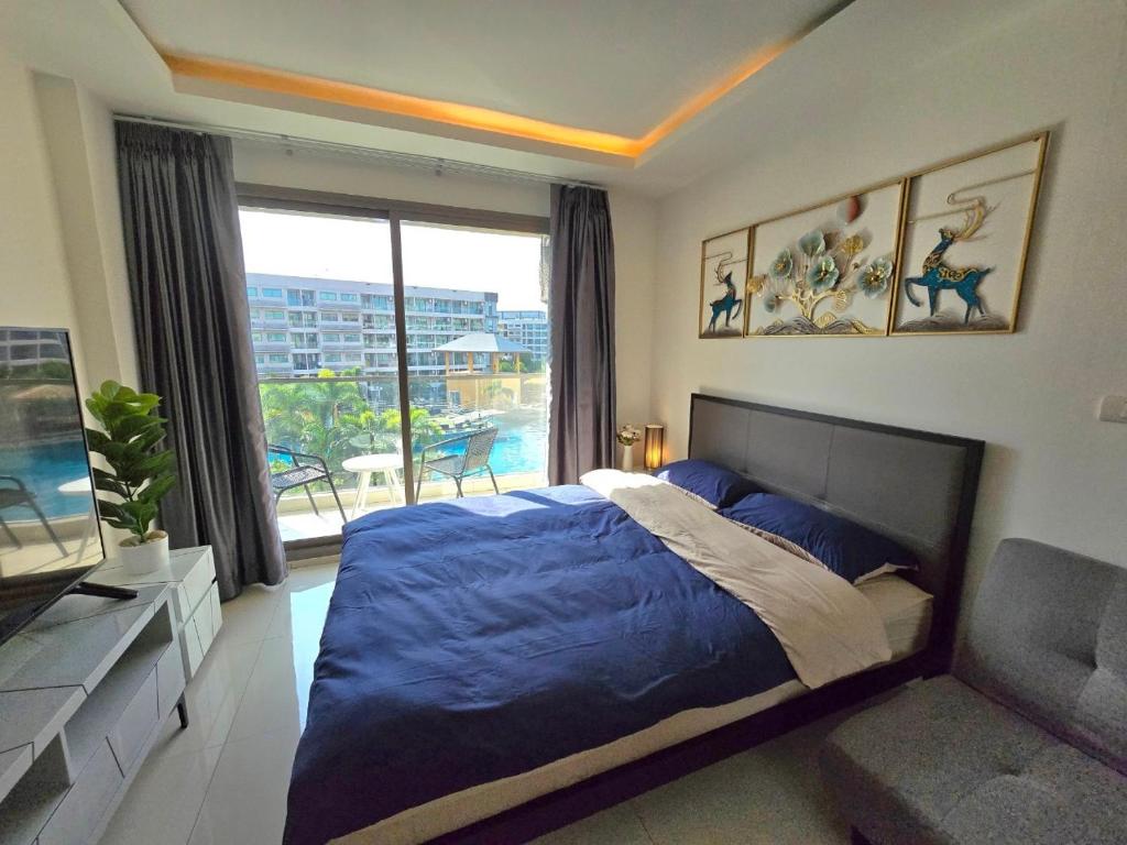 乔木提恩海滩Laguna beach condo resort 3 maldives pattaya top pool view ลากูน่า บีช คอนโด รีสอร์ต 3 พัทยา的一间卧室配有一张床、一张沙发和一个窗口