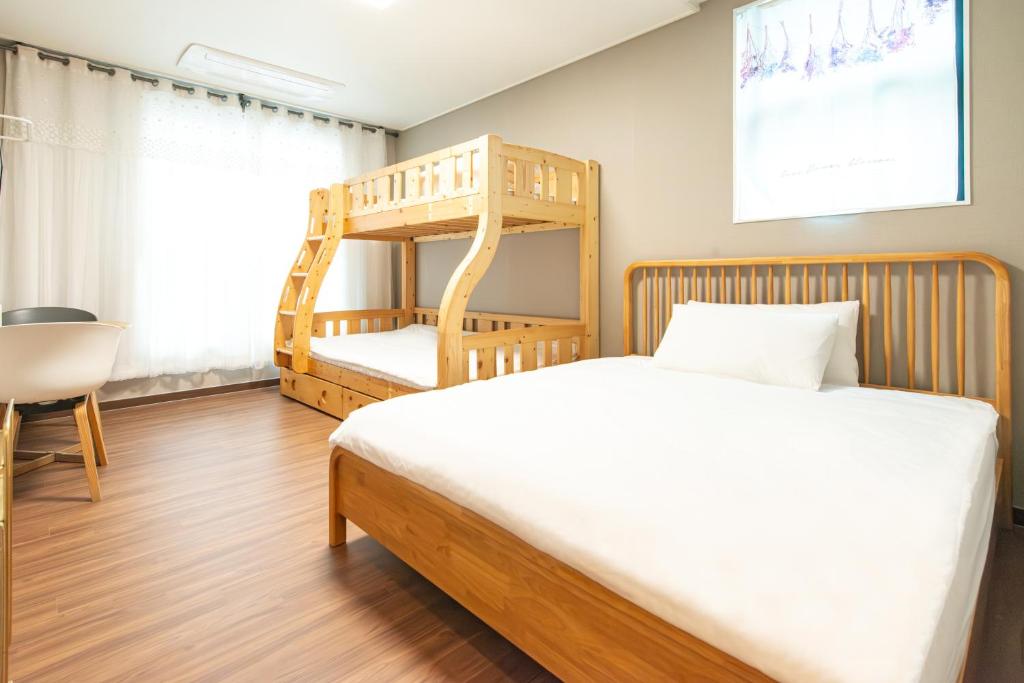 仁川市Incheon Airport Guest House King的一间卧室配有一张床和一张木制双层床
