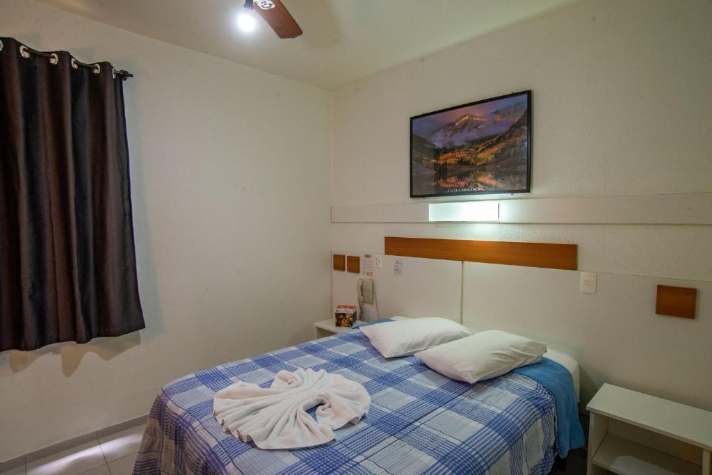 南卡希亚斯Bandeira Hotel的一间卧室配有一张带蓝白色毯子的床