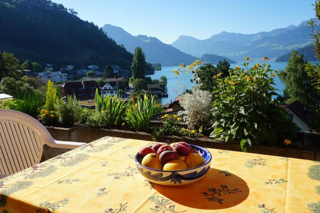 韦吉斯Charming Apartment w/Terrace on Lake and Mountain的坐在桌子上,一边欣赏风景,一边享用一碗水果
