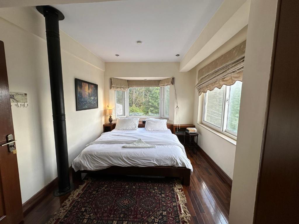 穆里Sarah's Lodge的一间卧室设有一张床和一个大窗户
