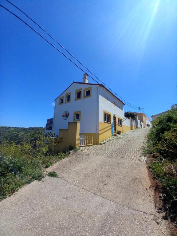 拉波塞拉Hostel on the Hill的土路上的白色和黄色建筑