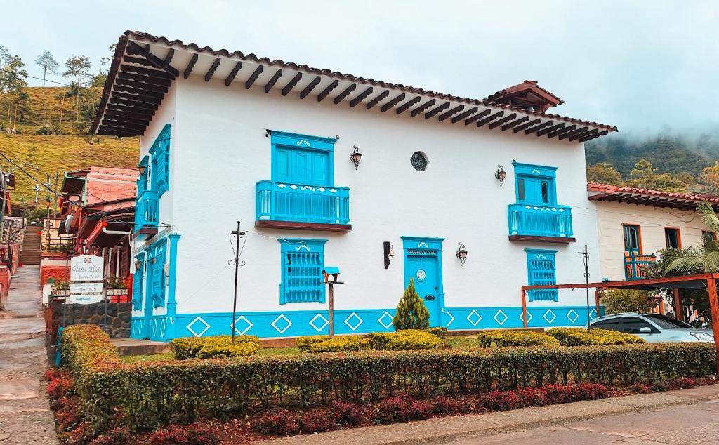 杰里科Villa Linda ApartaHotel的蓝色和白色的房子,设有蓝色的窗户和蓝色的百叶窗